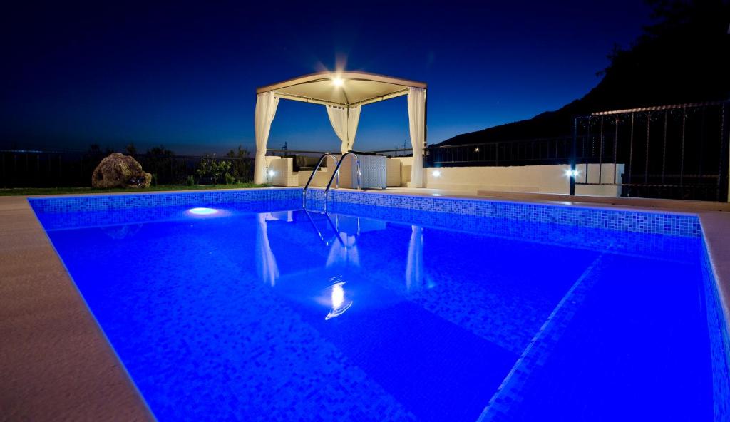 a swimming pool at night with a gazebo at Villa Filip Spa & Relax Makarska in Makarska