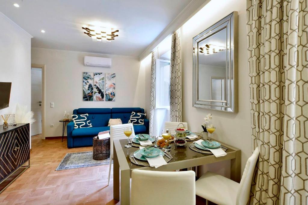 a dining room and living room with a table and chairs at Mar Luxury Suite in Corfu Town
