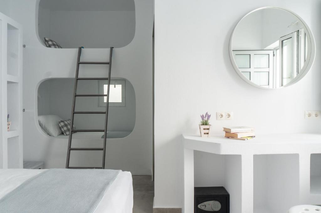 a bedroom with a ladder next to a mirror at Pelican Paros in Parikia