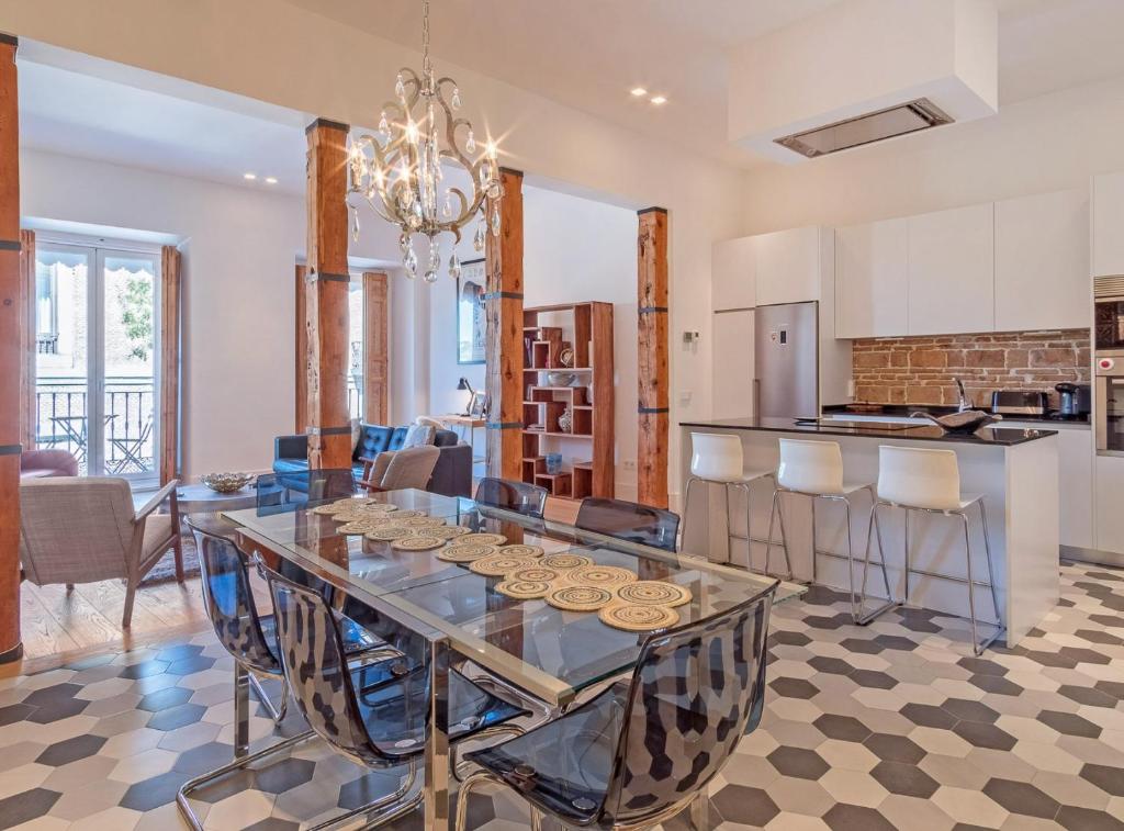 a kitchen and dining room with a glass table and chairs at Bailen Palacio Real in Madrid