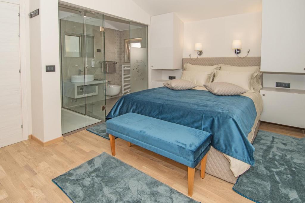 1 dormitorio con 1 cama grande con manta azul en Fra&Kat Rooms en Premantura