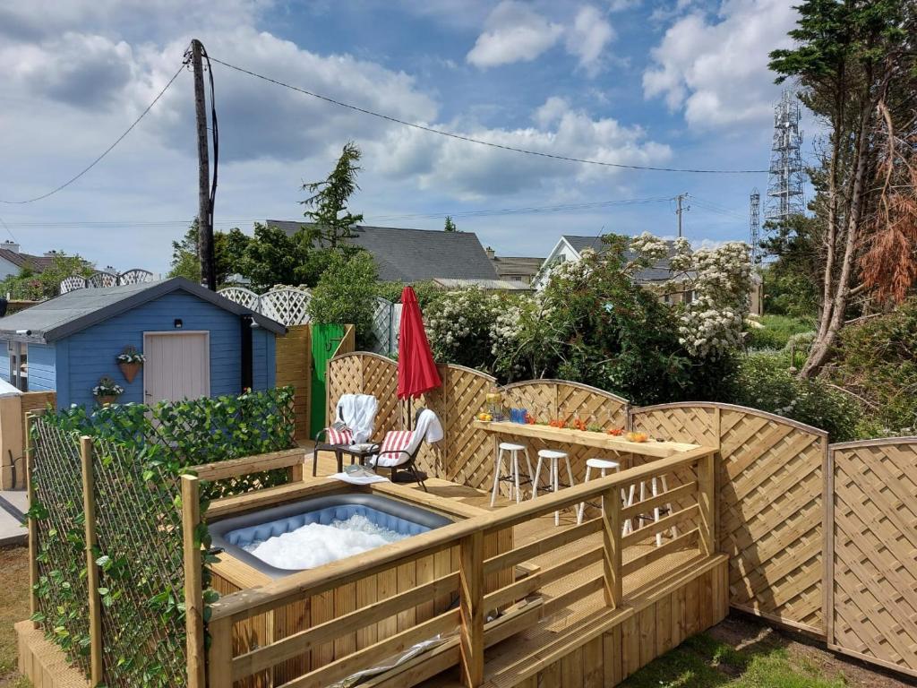 un jardín con bañera de hidromasaje sobre una valla de madera en Hillcrest House Self Catering Apartments, en Donegal