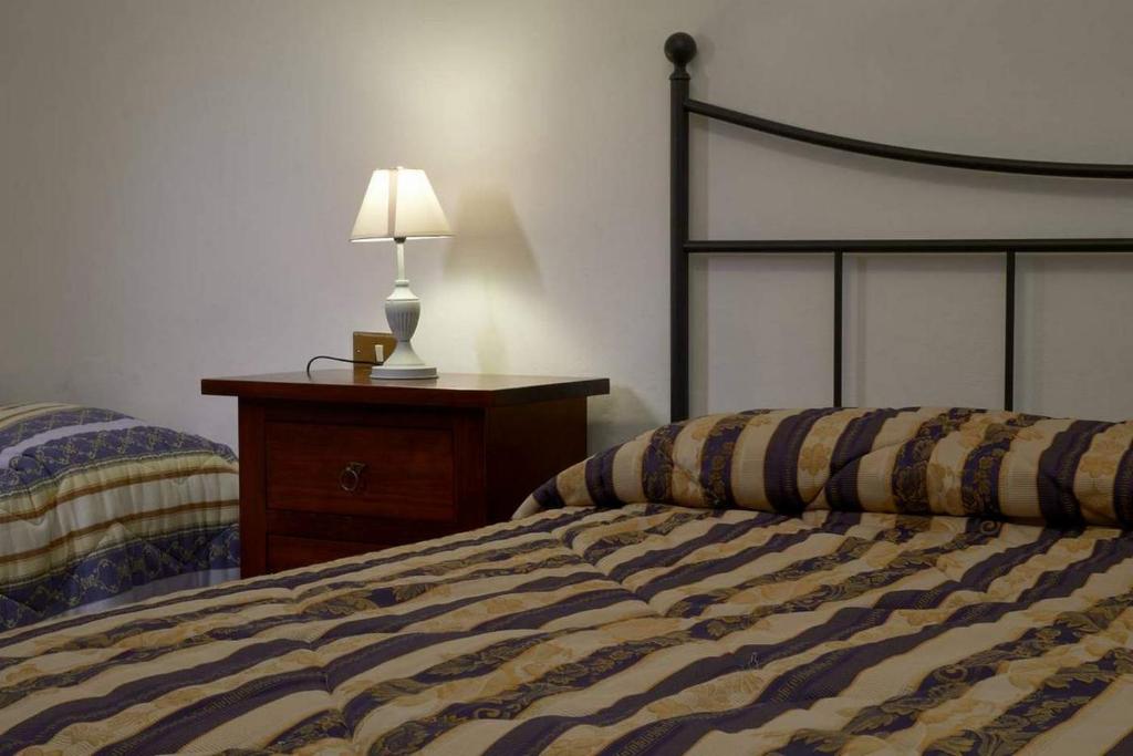 1 dormitorio con 1 cama y 1 mesa con lámpara en La Casa di Gloria - Residence affitta camere, en Badia Prataglia