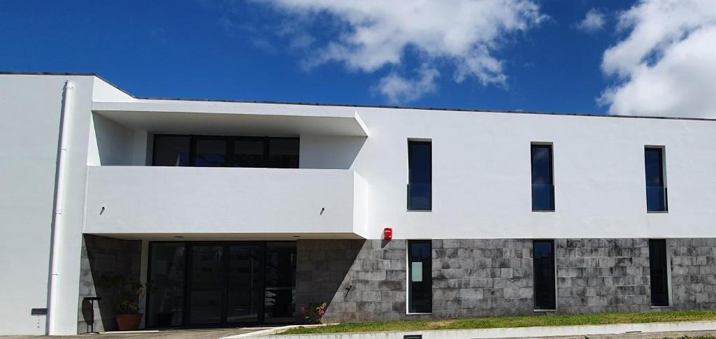 a white building with black windows and doors at PIO XII - ALOJAMENTO LOCAL in Ponta Delgada