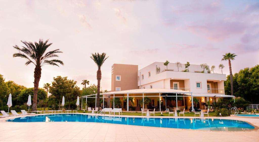 un resort con piscina e palme di Modica Palace Hotel a Modica