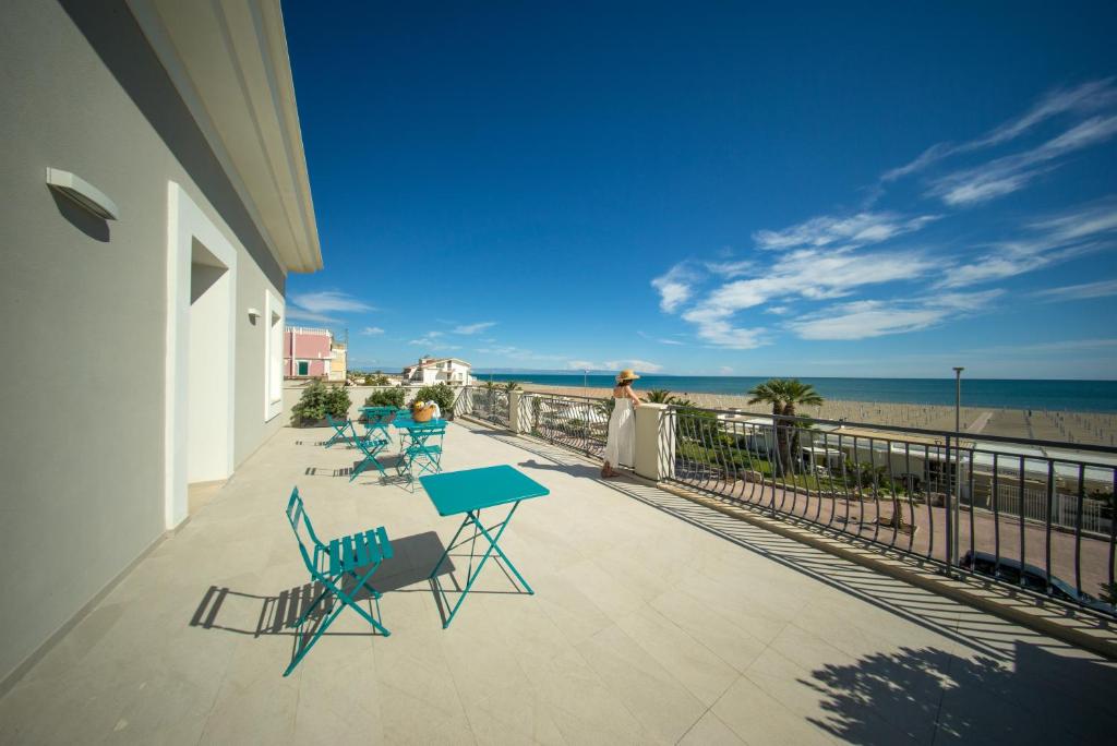 a balcony with a table and chairs and the beach at Palazzo Novecento in Margherita di Savoia