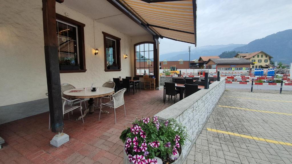 维尔德斯韦尔Gasthof Hirschen in Wilderswil的庭院配有桌椅和鲜花