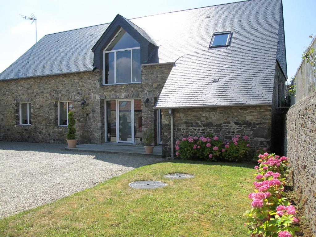 a stone house with flowers in front of it at Holiday Home La Lucerie - BAY402 by Interhome in Bretteville-sur-Ay