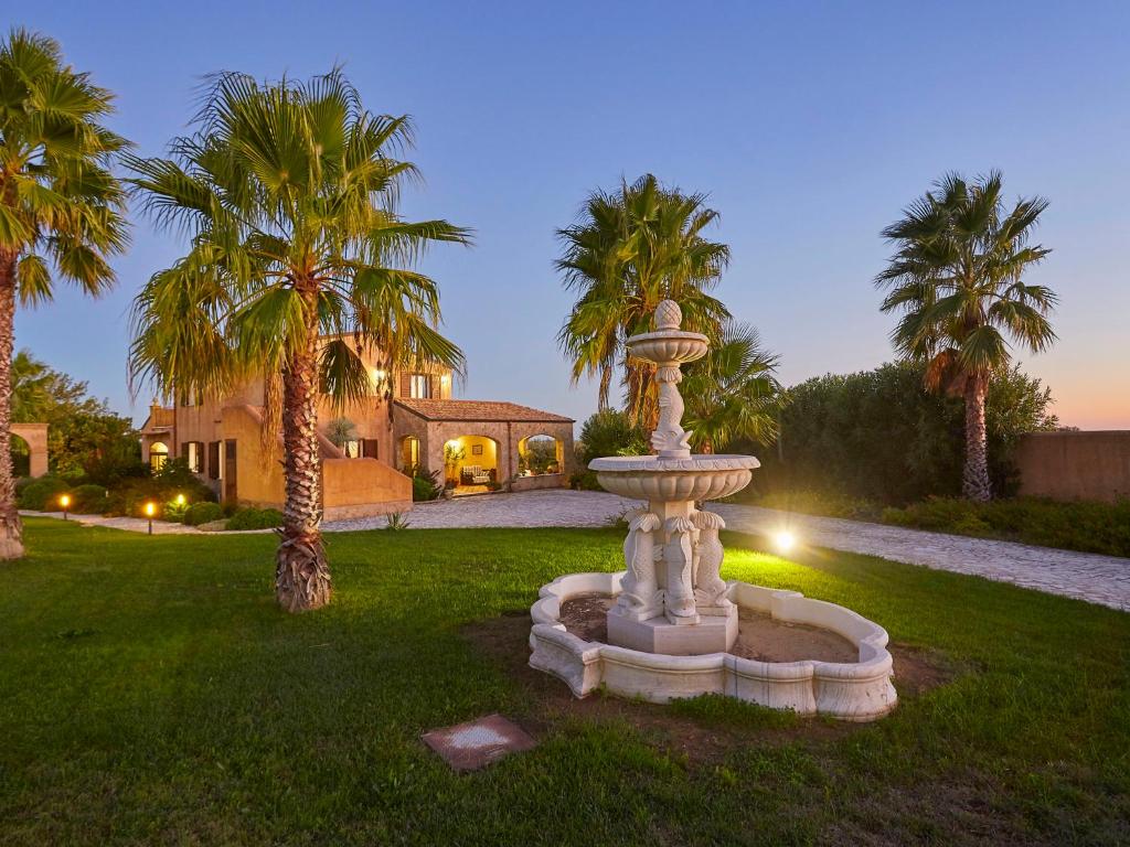 une fontaine au milieu d'une cour avec des palmiers dans l'établissement Villa Bel Villa by Interhome, à Marinella di Selinunte
