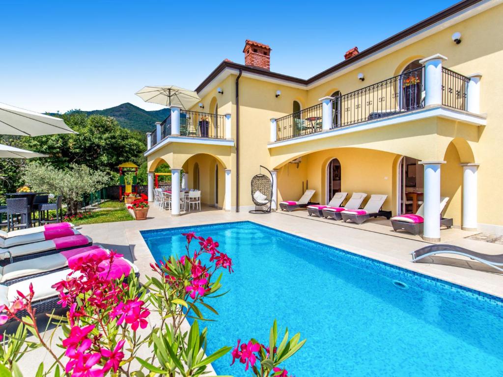 a villa with a swimming pool and a house at Holiday Home Villa Orhidea by Interhome in (( Marčići ))