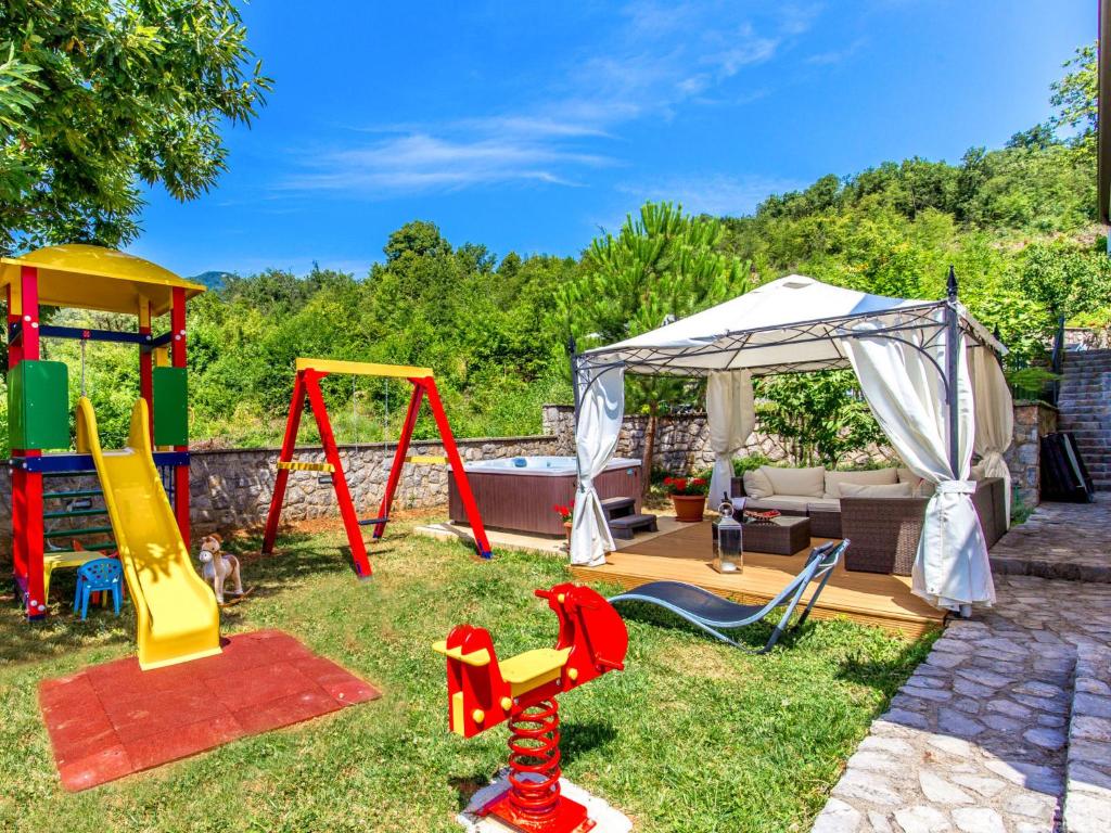 a backyard with a playground with a tent and swings at Holiday Home Villa Orhidea by Interhome in (( Marčići ))