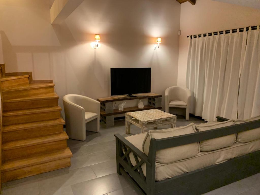 un soggiorno con divano e TV di Casa Las Margaritas a San Carlos de Bariloche