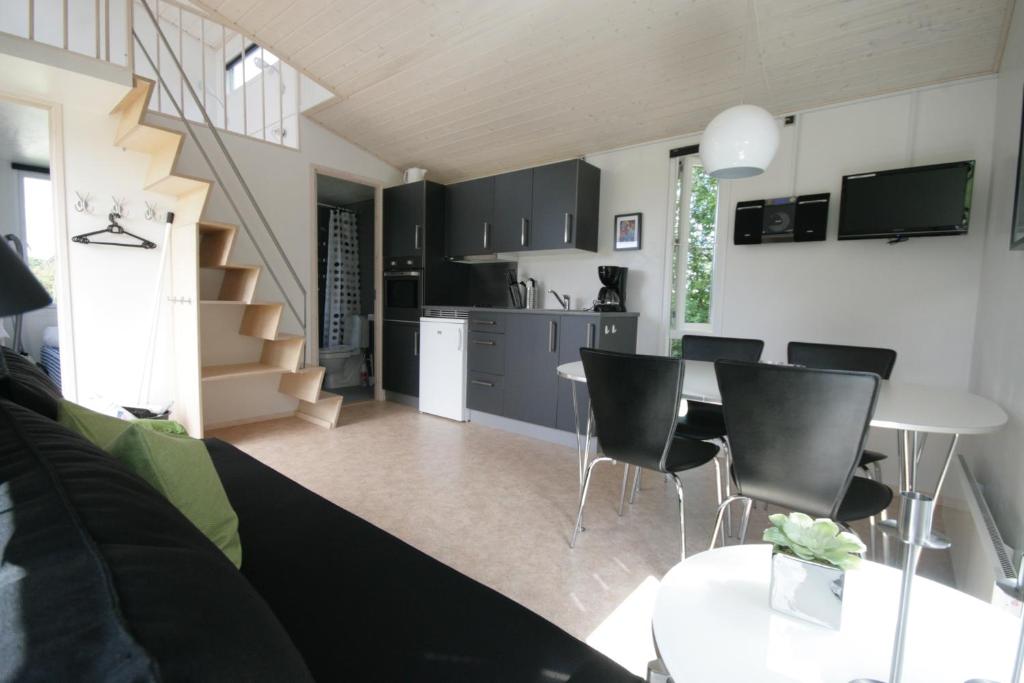 una cucina e un soggiorno con tavolo e sedie di Asaa Camping & Cottages ad Aså
