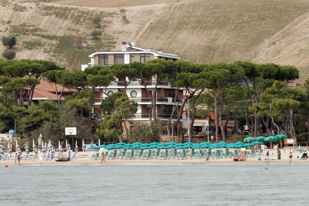 un hotel en la playa con un montón de sombrillas en Hotel Astoria, en Pineto