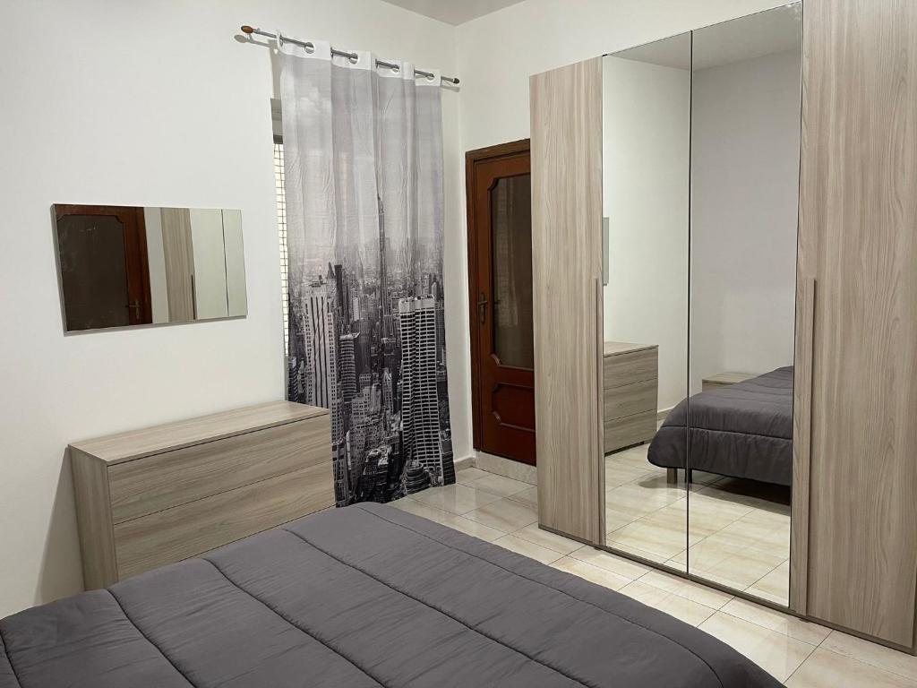 een slaapkamer met een spiegel, een bed en een televisie bij A Casa di Mimia in Avellino