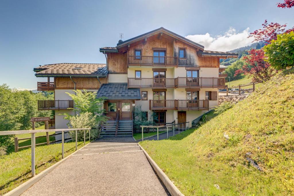 a large house on a hill with a pathway at Le Chevreuil - 3 chambres, terrasse, piscine in Flumet