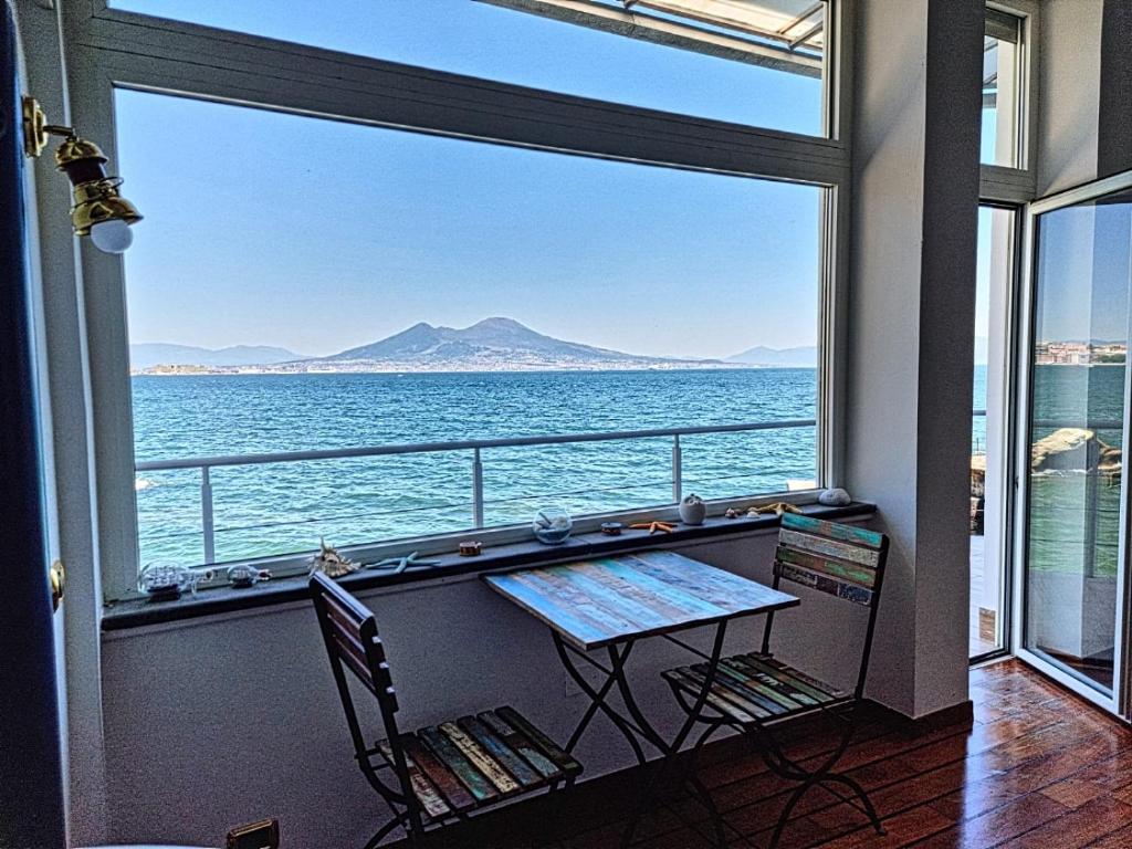 balcone con tavolo e vista sull'oceano di LA CASA SULL’ ACQUA a Napoli