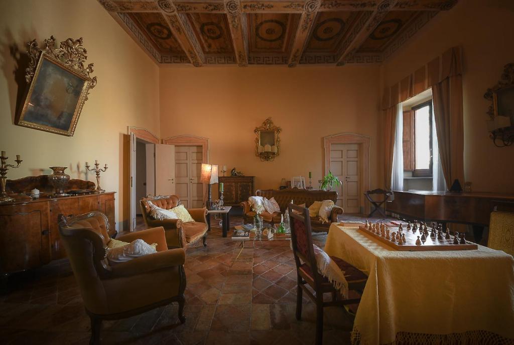 una sala de estar con 2 mesas y sillas y una habitación con en Palazzo Bonfranceschi, en Belforte del Chienti