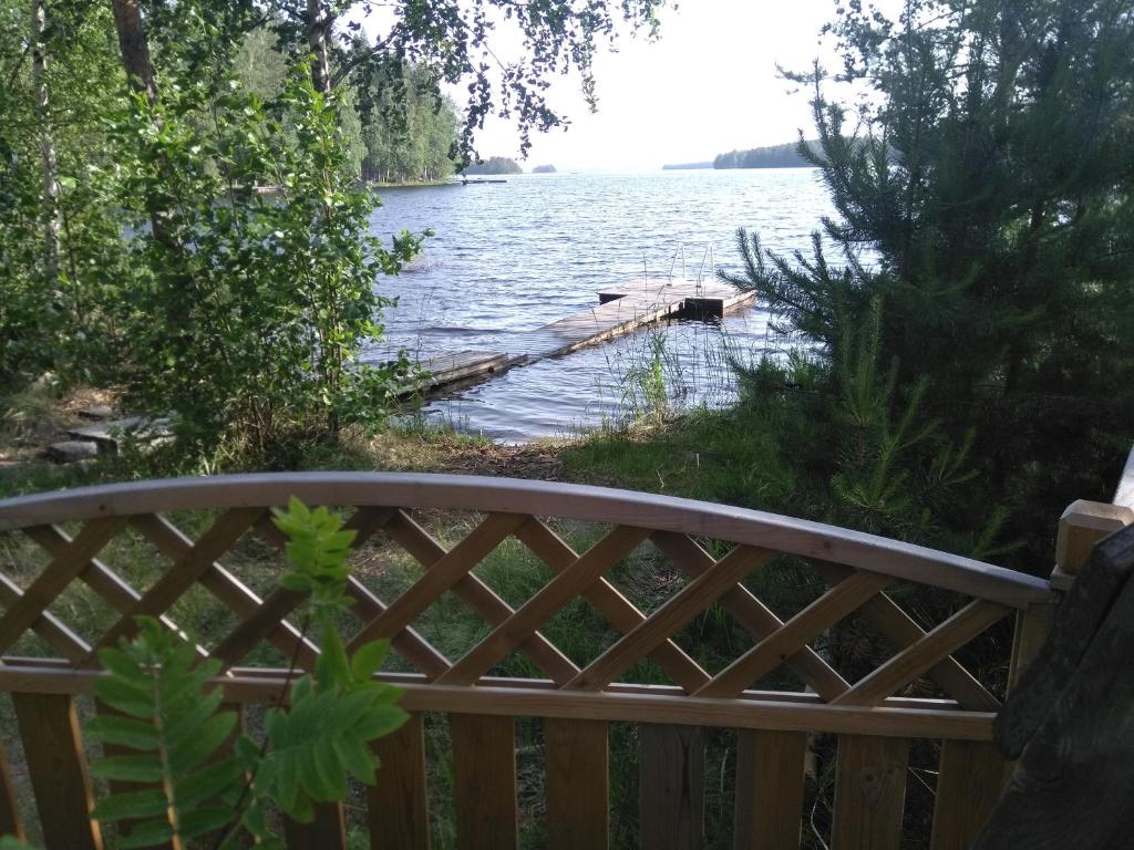 a wooden fence next to a body of water at Takalahti Lodge in Puumala