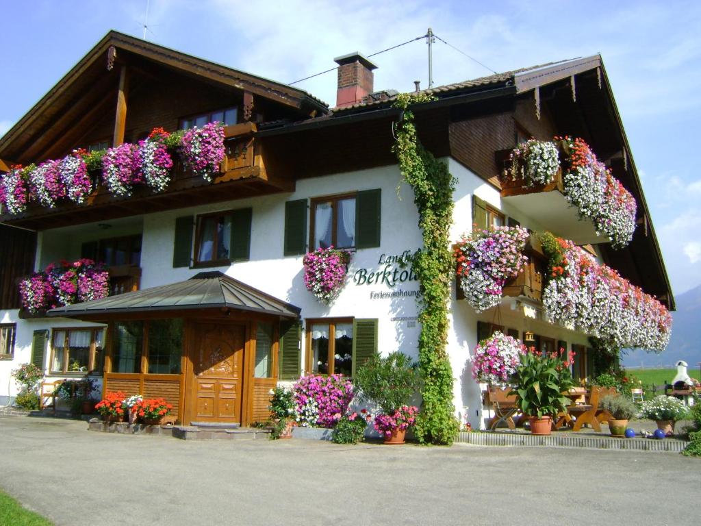 ein Gebäude mit vielen Blumen darauf in der Unterkunft Landhaus Berktold in Obermaiselstein