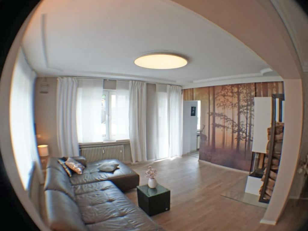 a living room with a leather couch and a table at Ferienwohnung Jill Schleiden in Schleiden