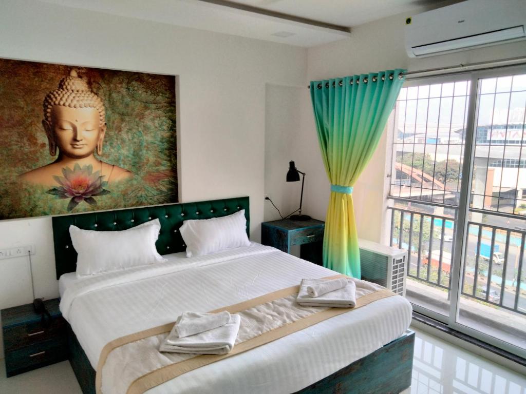 ein Schlafzimmer mit einem großen Bett und einem großen Fenster in der Unterkunft Atithistay Thane in Thane
