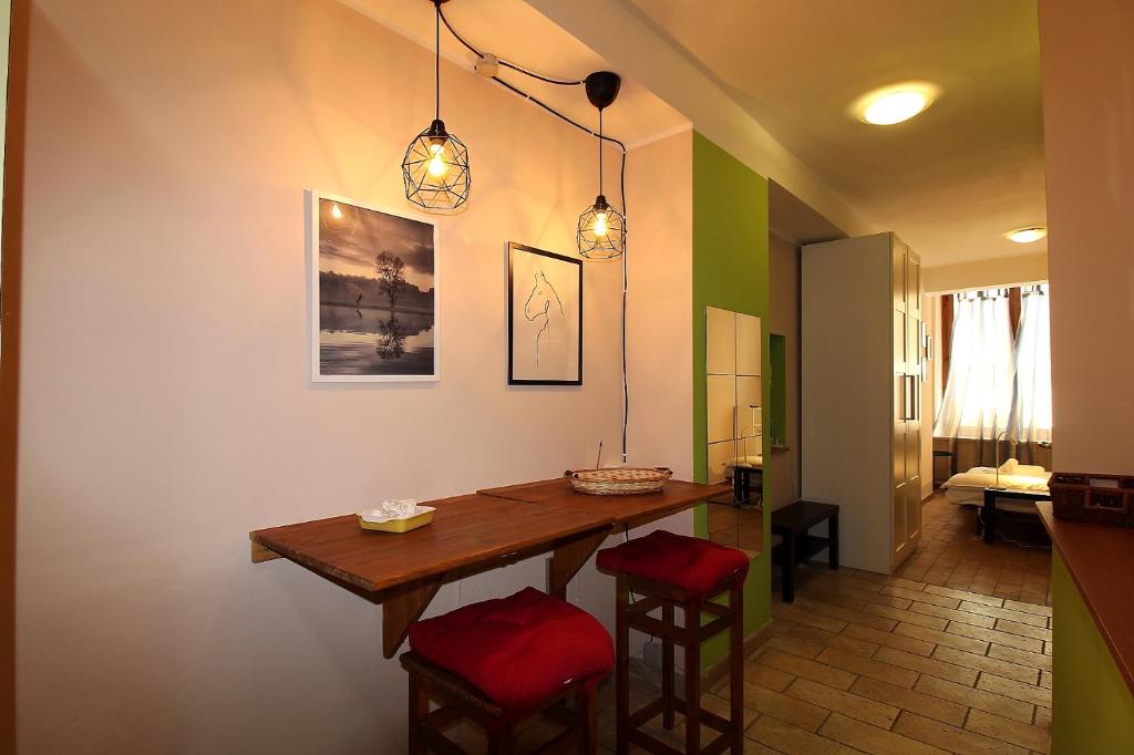een keuken met een houten tafel en 2 krukken bij Vado al teatro monolocale in centro per 2 in Ancona
