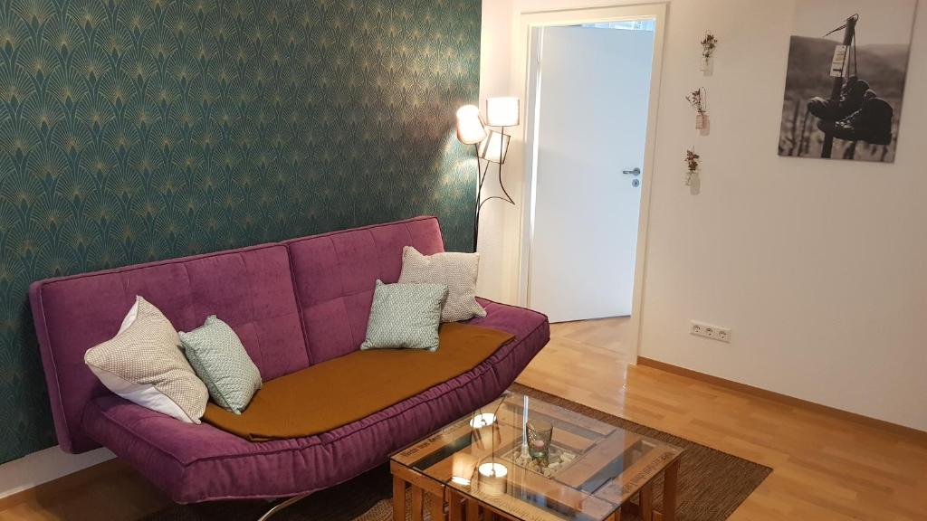 a purple couch in a living room with a table at FeWo -Kleines Moselglück- in Winningen bei Koblenz in Winningen