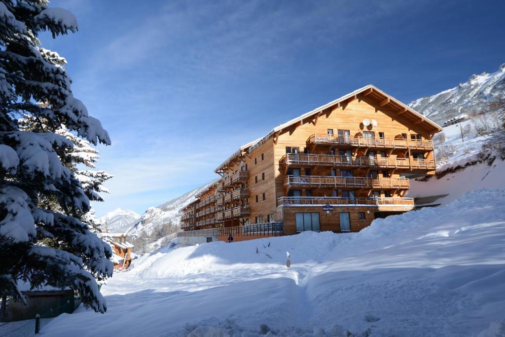 a ski lodge in the snow with snow covered trees at Résidence Odalys Pra Sainte Marie in Vars