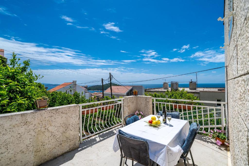 a table on a balcony with a view of the ocean at Apartments Kazo in Dubrovnik
