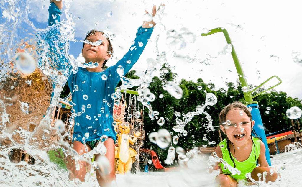 dos niños jugando en el agua en un parque acuático en LACQUA com PROMOCOES EM OUTROS PARQUES E DESCONT O, en Caldas Novas