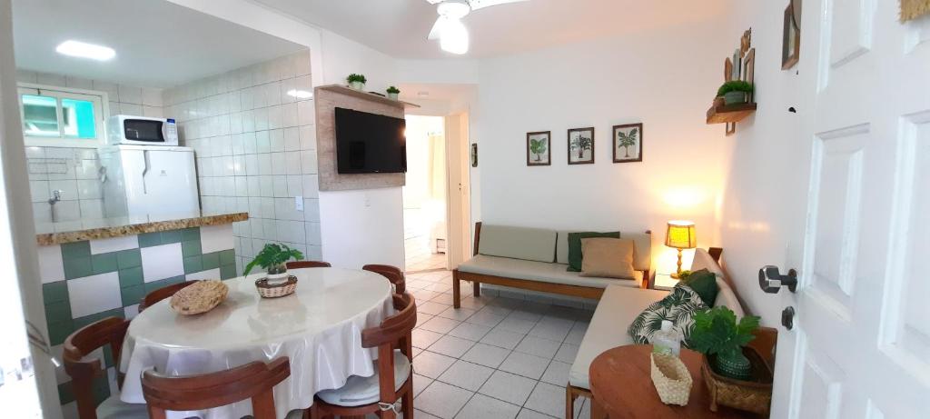 a living room with a table and a kitchen at Apto 518 - Golden Village Taperapuã in Porto Seguro