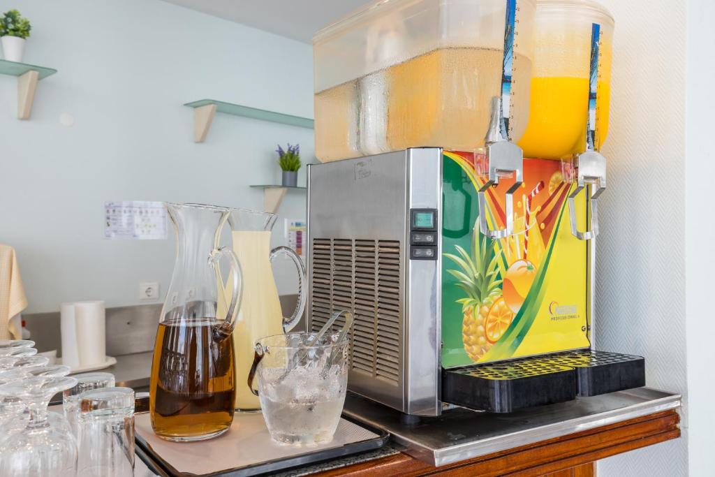 a kitchen counter with a mixer and a glass of water at Hotel Residencial Colibri in Costa da Caparica