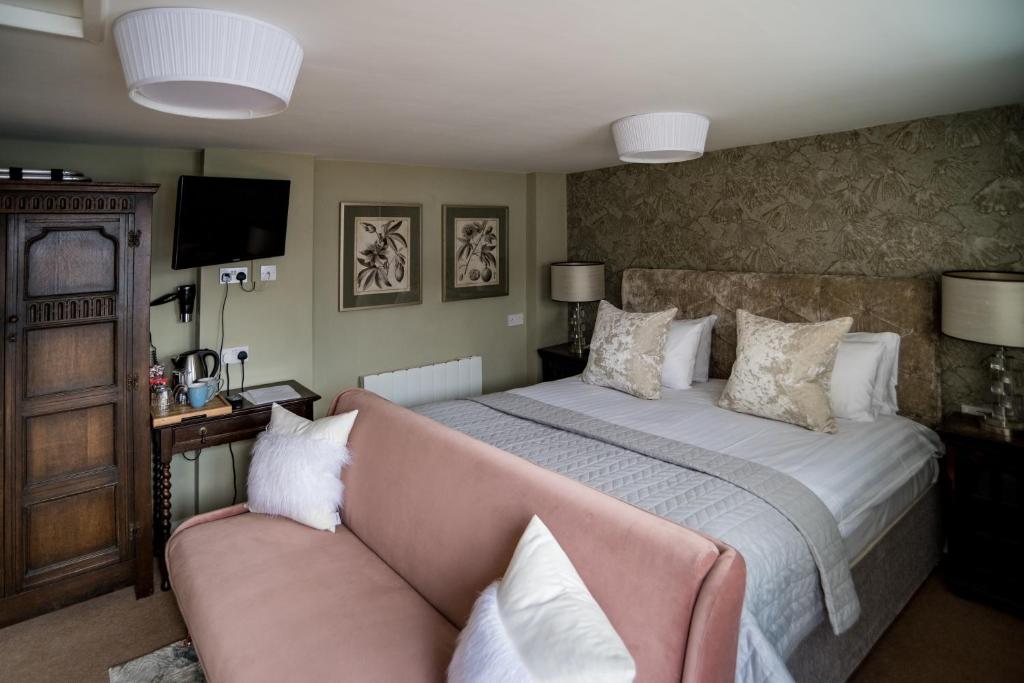 um quarto com uma cama grande e um sofá em The Brewers Inn em Milton