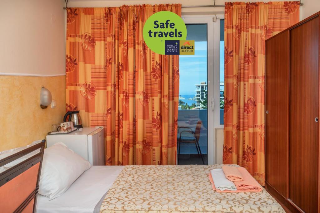 a bedroom with a bed and a sign that says sale travels at Apartments Pod Lozom with Seaview in Petrovac na Moru