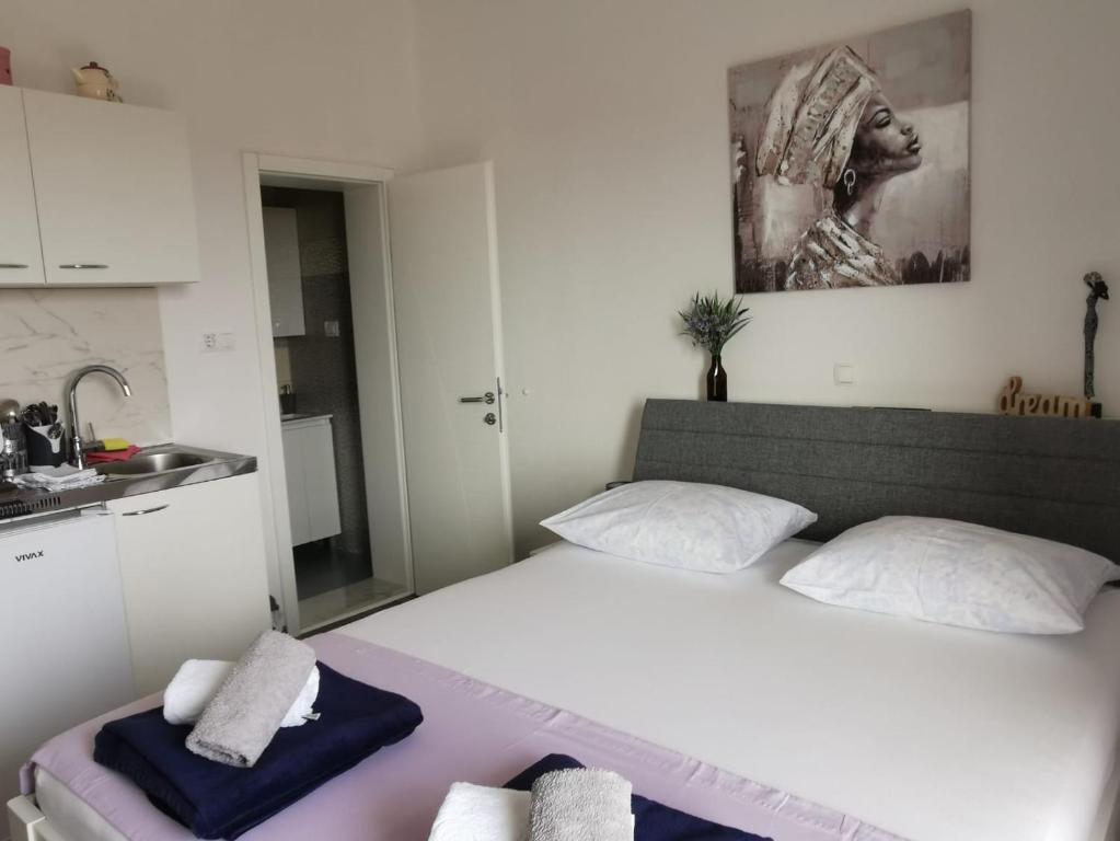 a bedroom with a bed and a kitchen with a sink at M&M`s- lovely apartments in Baška Voda