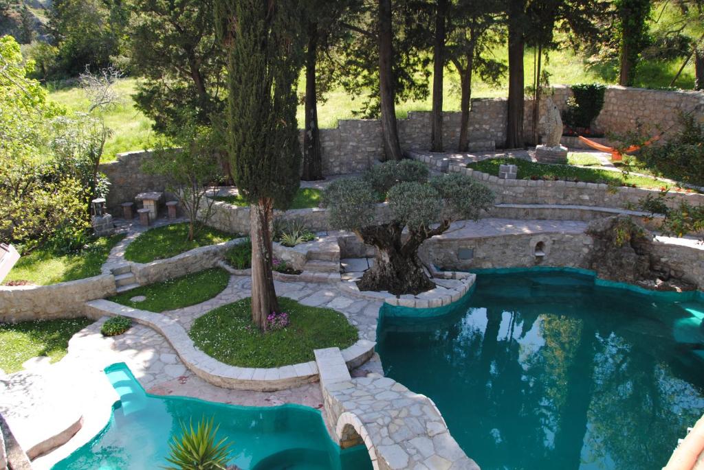 a swimming pool in a backyard with a landscaping at Villa Old Mill in Herceg-Novi