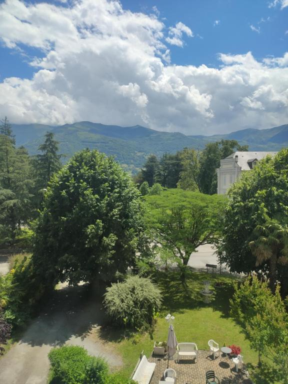 Elle offre une vue sur un jardin avec des chaises et des arbres. dans l'établissement Studio vue Tourmalet dans villa historique "Victoria", à Argelès-Gazost