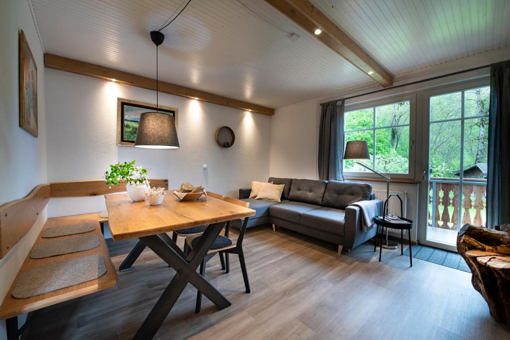 ein Wohnzimmer mit einem Tisch und einem Sofa in der Unterkunft Apartma in sobe PR'OBJAN in Bohinj