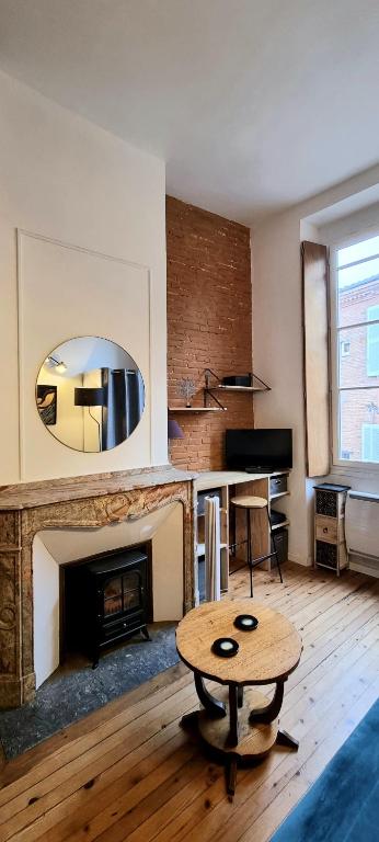 un salon avec une table et une cheminée dans l'établissement DUPLEX CHARMANT- Hypercentre - Clim - Métro - WiFi, à Toulouse