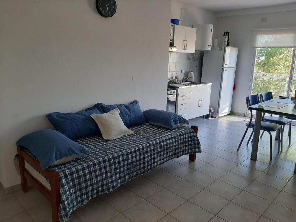 a living room with a couch with blue pillows at Departamento Céntrico Las Estaciones in Sunchales