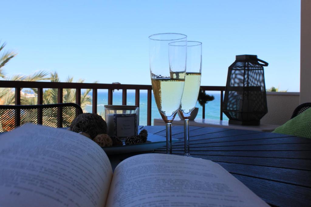 um livro aberto sobre uma mesa com copos de vinho em LUBINA DEL SOL em Mijas Costa