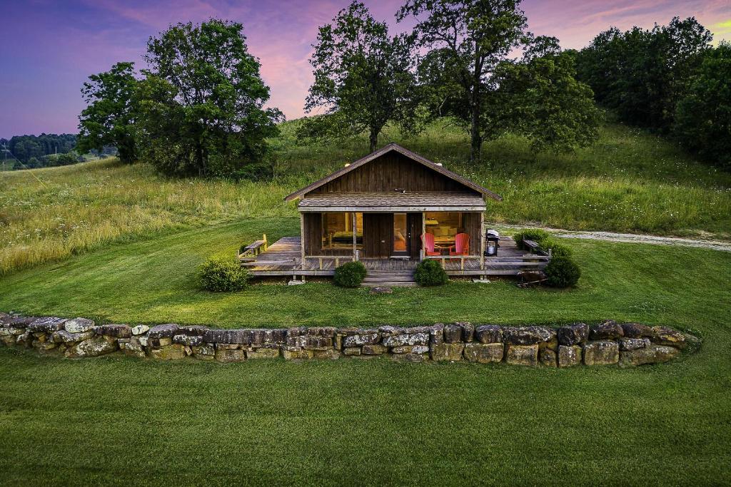 a small house on a hill with a green field at This is the ultimate in private escape in Ponca