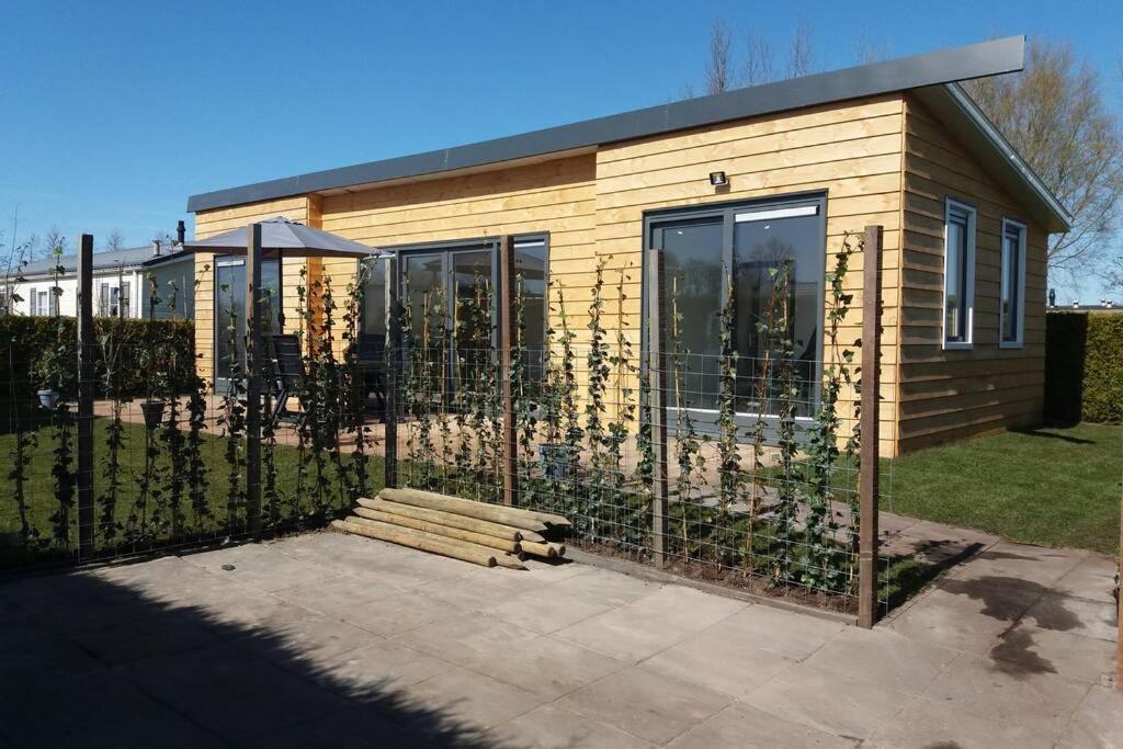 a small house with a fence in front of it at luxe Vakantie bungalow met 3 slaapkamers in Dronrijp