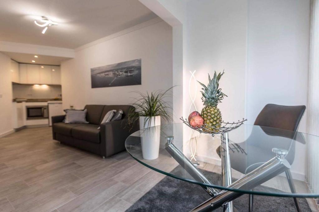 a living room with a glass table with a pineapple on it at Studio La Concha direkt am Meer in Torrox Costa