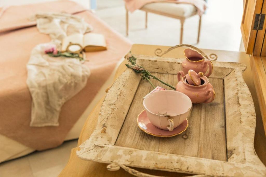 a tray with a tea pot and a tea set on a table at B&B Antico Telaio in Santa Maria Navarrese