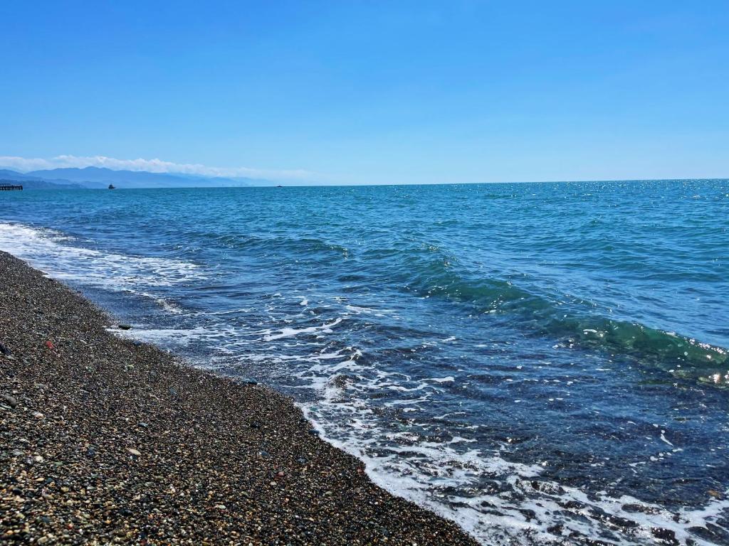 a rocky beach with the ocean in the background at Chveni Ezo Boutique Hotel in Kobuleti