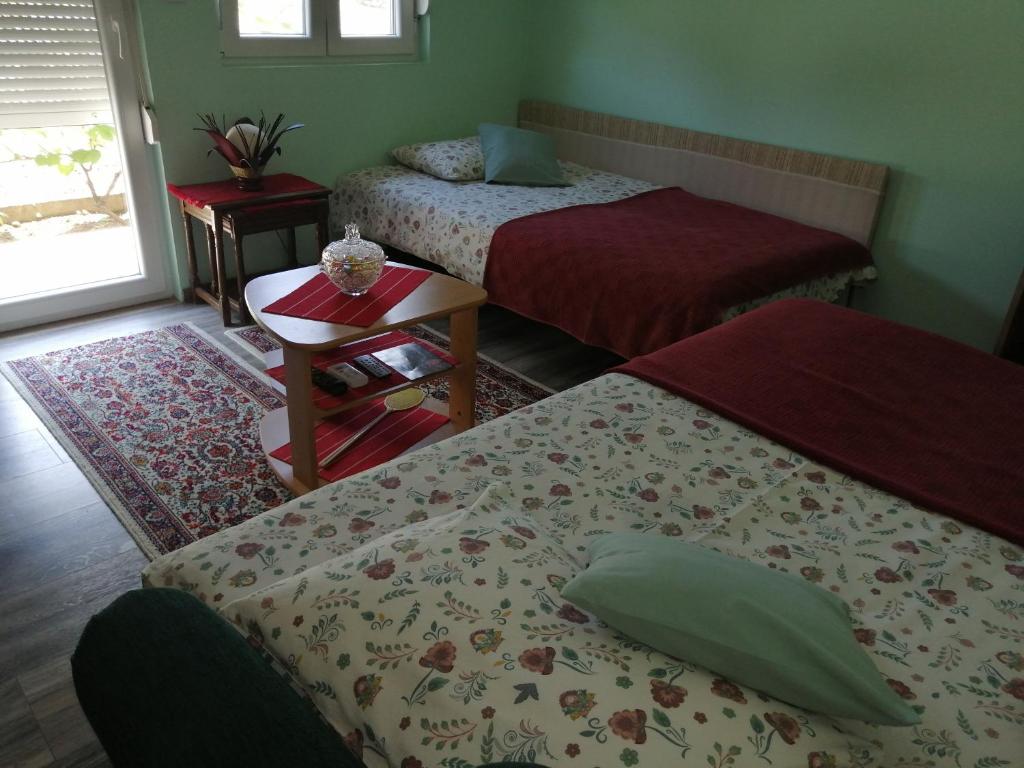a bedroom with two beds and a table and a window at Airplane Apartment T&amp;T in Surčin