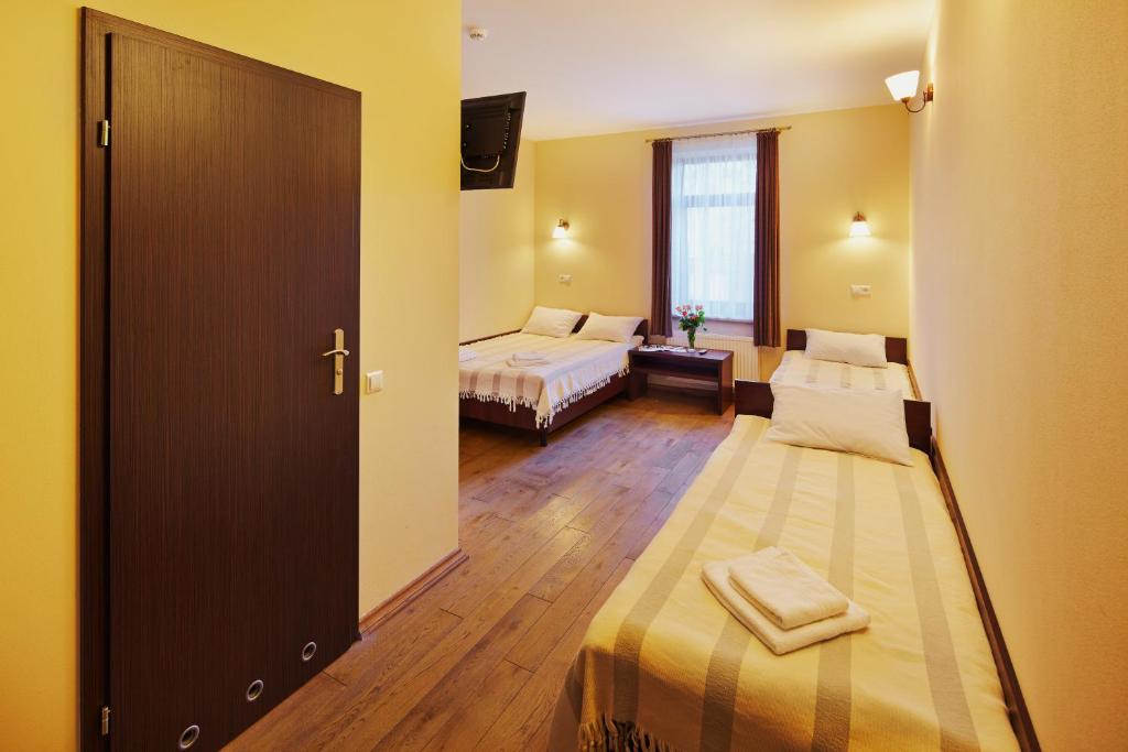 a hotel room with two beds and a sliding door at Medova Pechera in Lviv