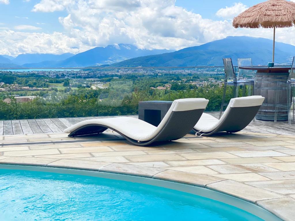 - deux chaises blanches installées à côté de la piscine dans l'établissement The Panoramic, à Pringy